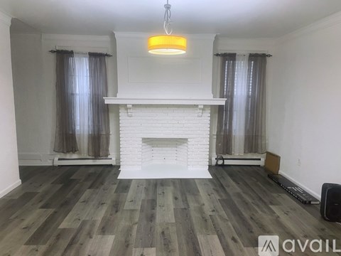 A living room with a fireplace and wooden flooring.