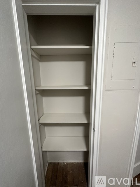 A white pantry with shelves and a door.