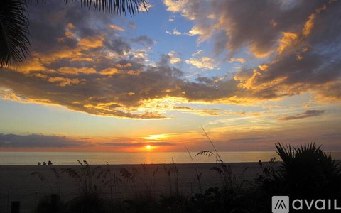A beautiful sunset over the ocean with people enjoying the view.