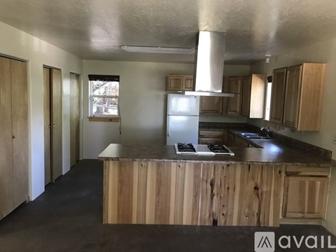A kitchen with wooden cabinets and a black countertop.