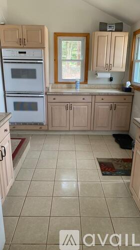A kitchen with a white oven and cabinets.