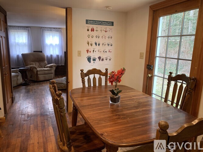 A dining room with a wooden table and chairs.