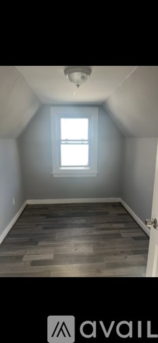 A room with a window and wooden flooring.
