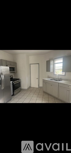 A kitchen with a refrigerator, oven, and sink.