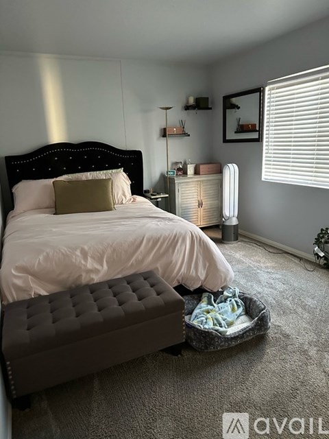 A bedroom with a large bed and a bench.