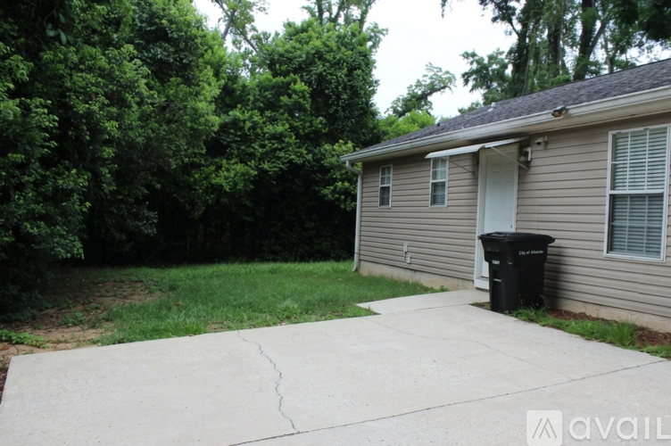 A house with a driveway and a trash can in front.