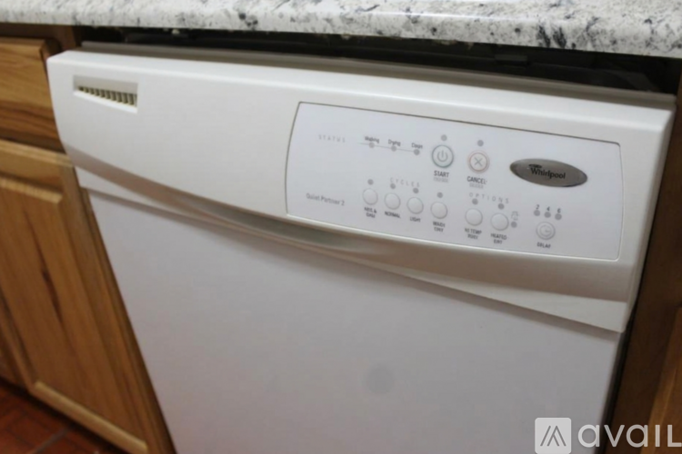 A white Whirlpool dishwasher is in a kitchen.