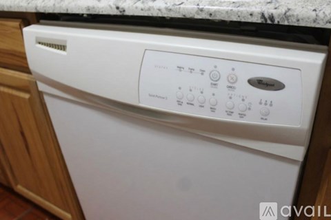 A white Whirlpool dishwasher is in a kitchen.
