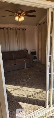 A room with a ceiling fan and a couch.