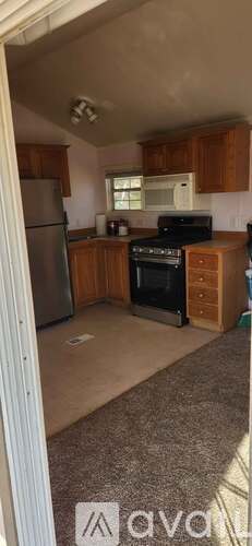 A kitchen with wooden cabinets and a refrigerator.