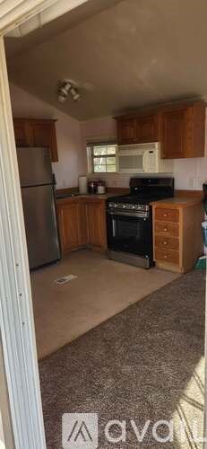 A kitchen with wooden cabinets and a refrigerator.