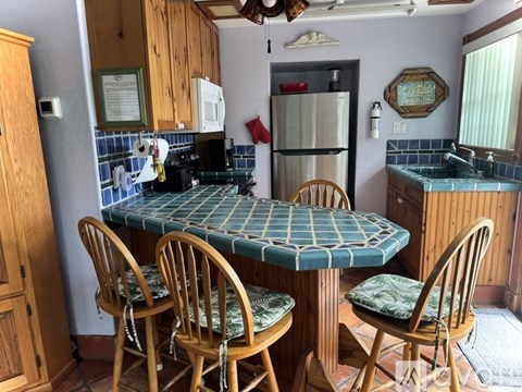 A kitchen with a table and chairs.