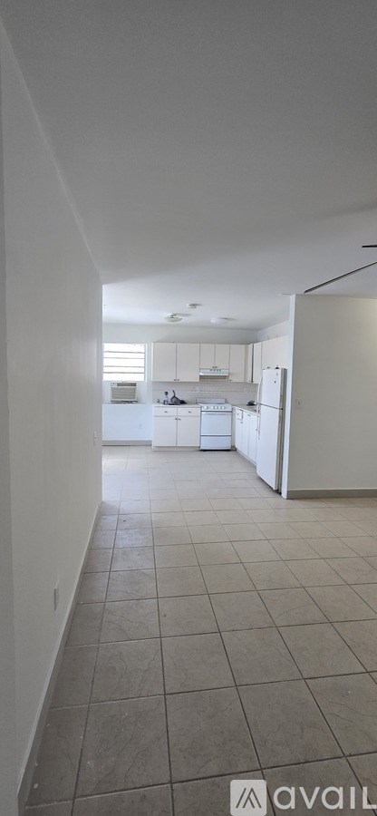 A kitchen with white cabinets and a white refrigerator.
