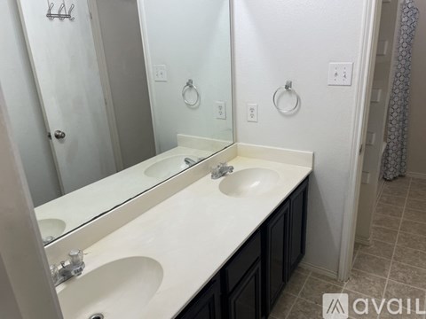 A bathroom with two sinks and a large mirror.