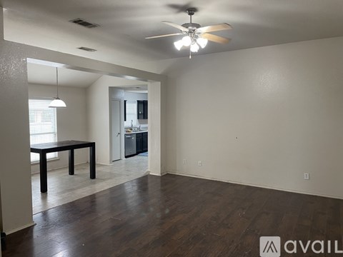 A room with a ceiling fan and a dining table.