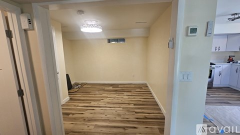 A room with wooden flooring and white walls.