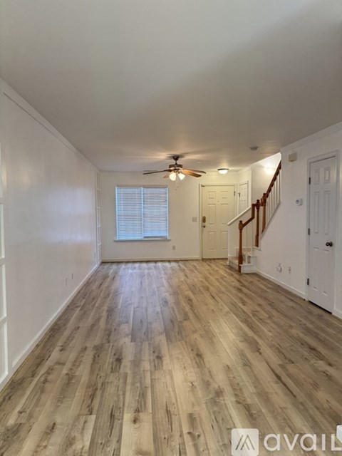 A room with wooden flooring and a staircase.