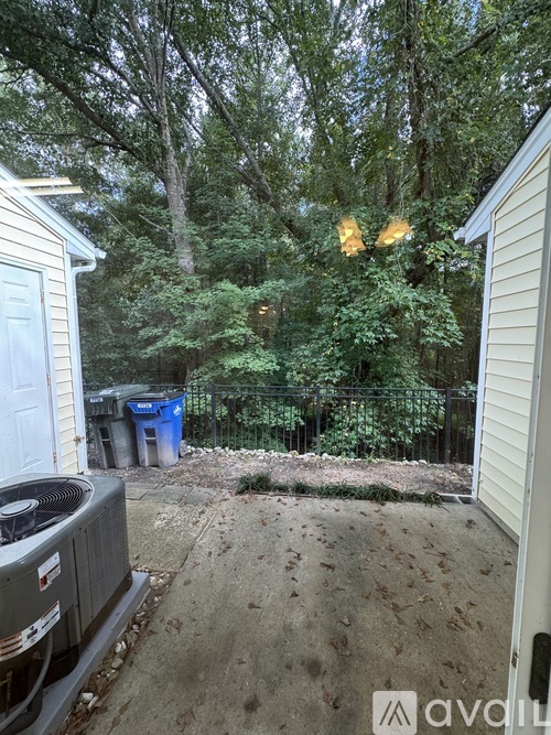A backyard with a fence, trees, and a shed.