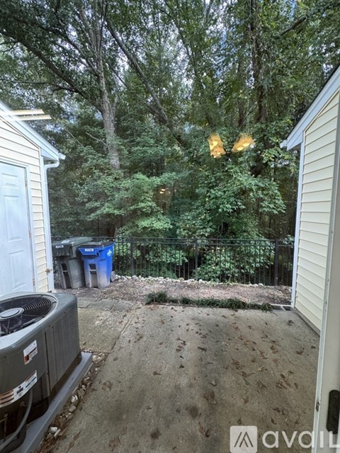 A backyard with a fence, trees, and a shed.