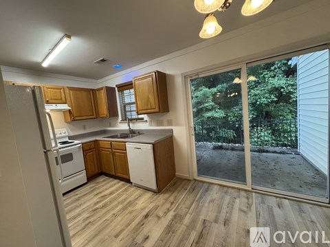 A kitchen with wooden cabinets and a refrigerator.