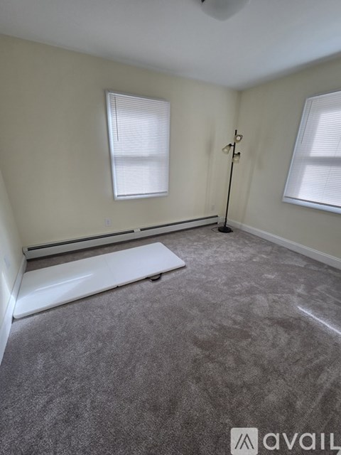 A room with grey carpet and a white radiator.