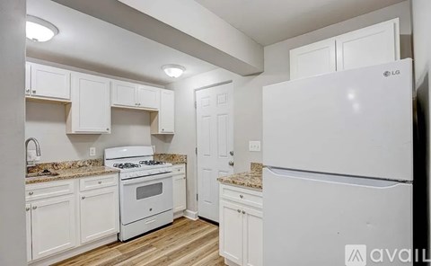 A kitchen with white appliances and cabinets.
