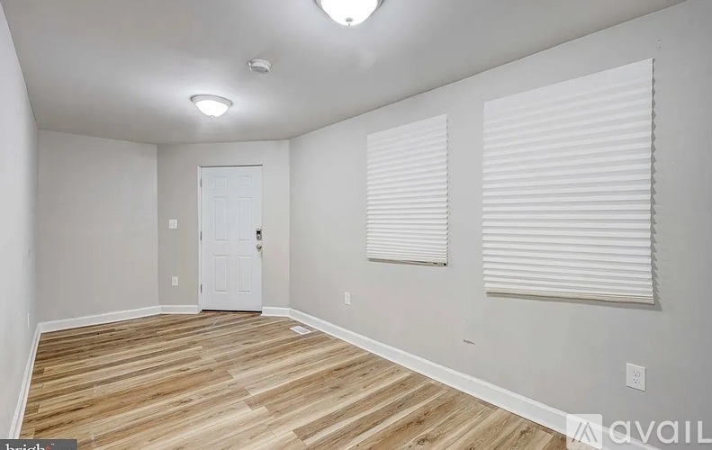 A room with wooden flooring and a white door.