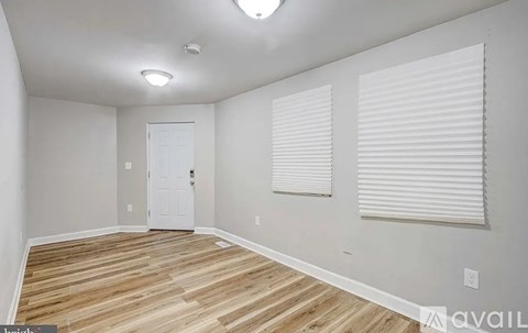 A room with wooden flooring and a white door.