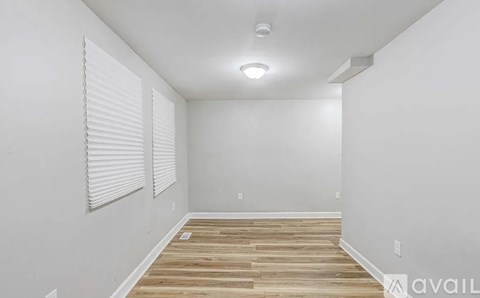 A room with wooden flooring and white walls.