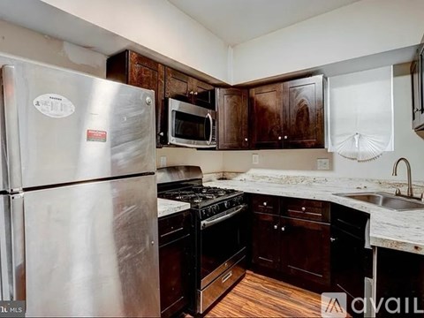 A kitchen with a stainless steel refrigerator, microwave, oven, and sink.