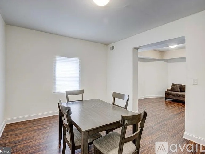 A dining room with a wooden table and chairs.