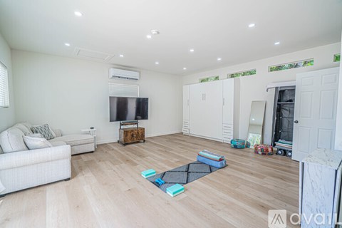 A living room with a white couch and a television on a wooden stand.