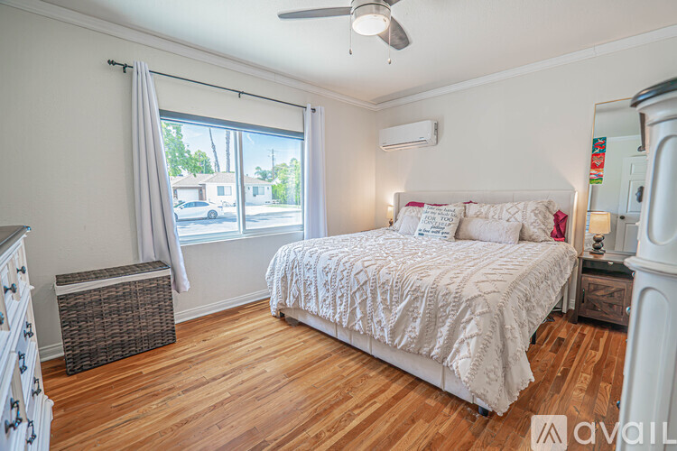 A bedroom with a large bed and a window with a view of the street outside.