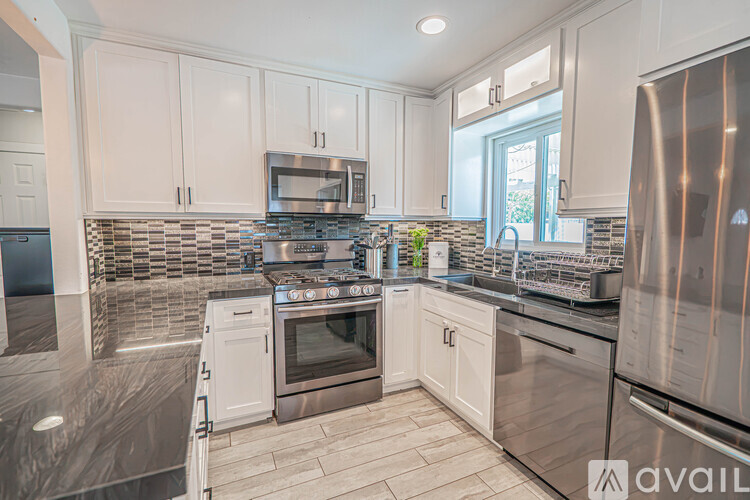 A kitchen with white cabinets and stainless steel appliances.