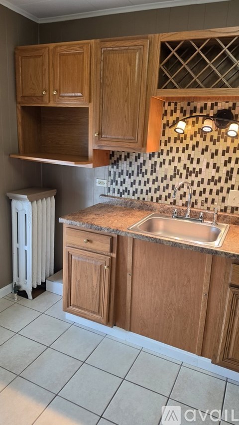 A kitchen with wooden cabinets and a tiled backsplash.