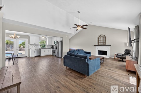 A living room with a blue couch and a fireplace.