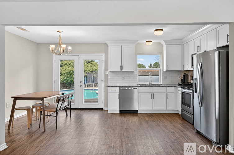 A kitchen with a table and chairs and a refrigerator.