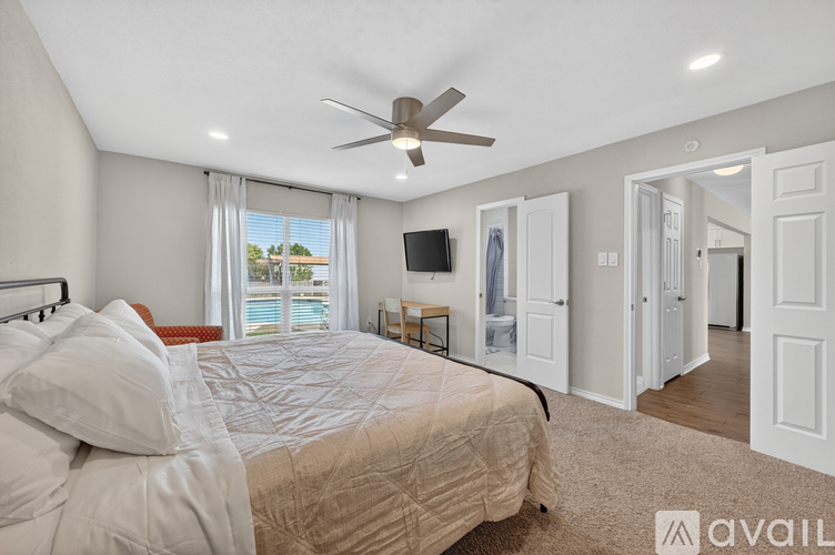 A bedroom with a large bed and a ceiling fan.