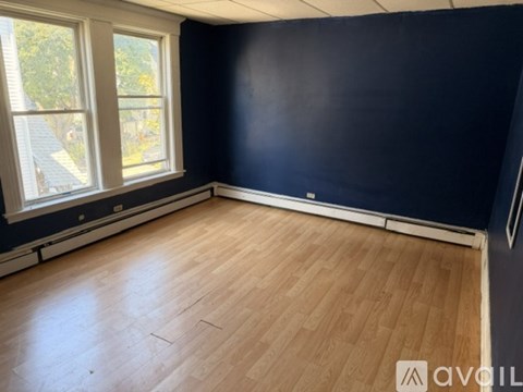 A room with wooden flooring and a window.