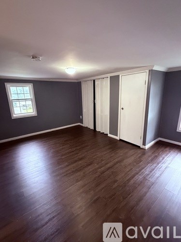 A room with wooden flooring and a window.