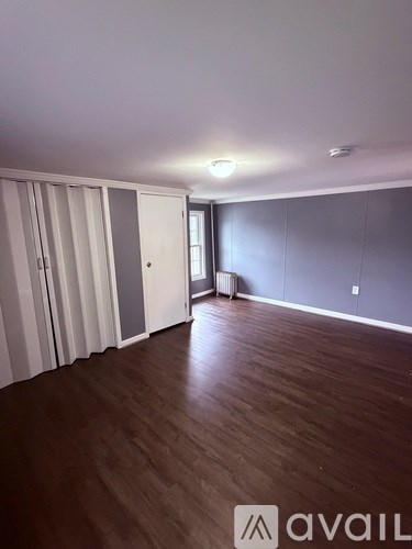 A room with wooden floors and a wall of cabinets.