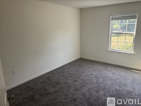 A room with a carpeted floor and a window.