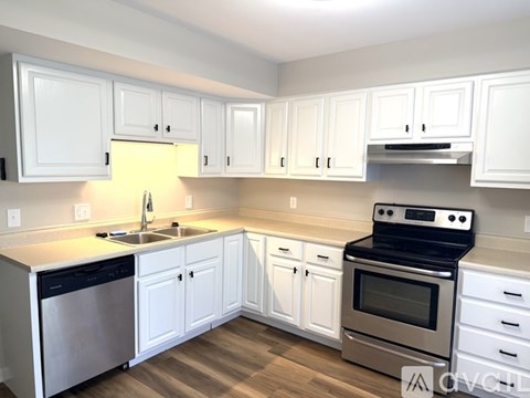 A kitchen with white cabinets and stainless steel appliances.