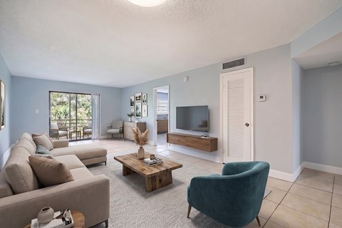 A living room with a couch, chair, and television.