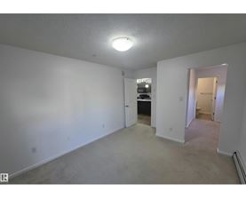 A spacious room with a doorway leading to another room.