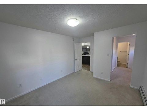 A spacious room with a doorway leading to another room.