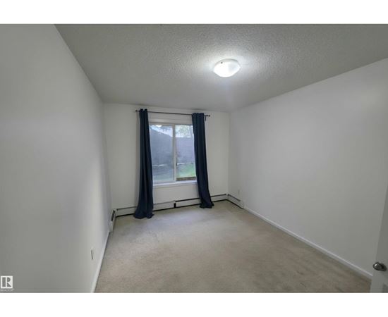 A room with a window and curtains.