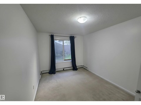 A room with a window and curtains.