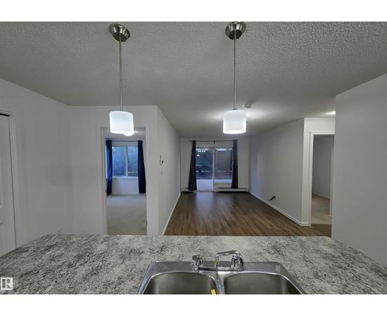 A kitchen with granite countertops and a double sink.