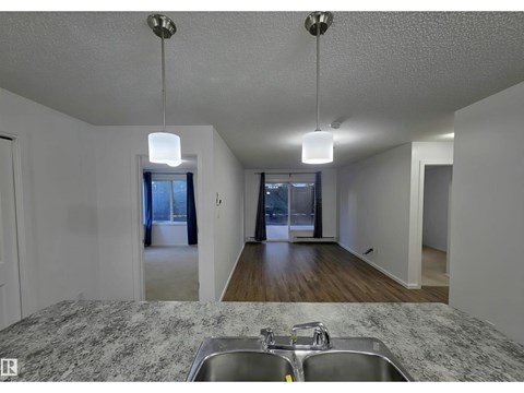 A kitchen with granite countertops and a double sink.